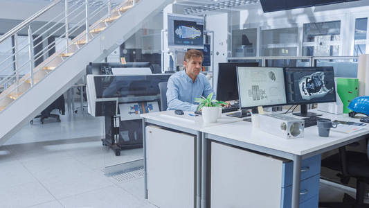 专家在明亮的工程设施办公室里用电脑绘图.照片