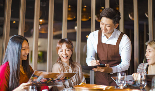 年轻帅气的服务员在火锅里点菜照片