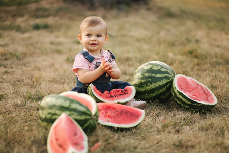 可爱的小西瓜可爱的小女孩笑着吃西瓜.穿牛仔裙的女孩.