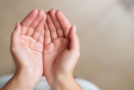 一个女孩张开的手掌折叠在一起,特写,俯视照片