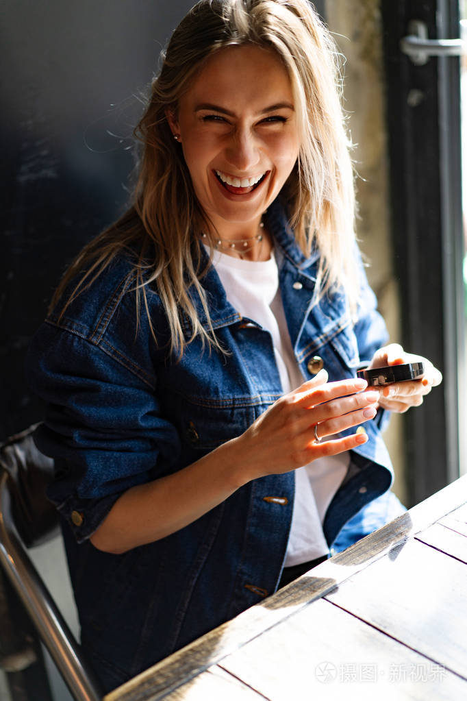 beautiful woman in a cafe looks in the mirror straightens 照片