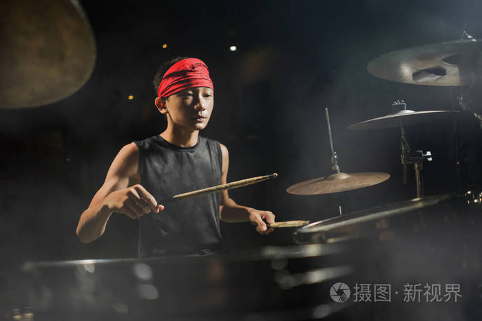 少年摇滚乐队鼓手.酷炫才华横溢的亚裔美国混血少年头戴头巾打鼓,在漆