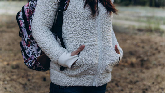 在寒冷的秋天,女人把手放在口袋里保暖.照片