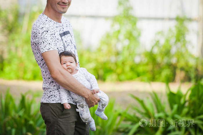 小女孩在父亲慈爱的手中新生儿在男性怀抱中睡觉的特写肖像年轻快乐的