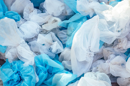 医用垃圾垃圾桶里的白色旧医用鞋套.卫生和保护的概念.环境污染照片