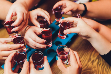 一组人在博克背景前用葡萄酒或香槟碰杯的特写镜头.照片
