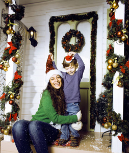 圣诞快乐的一家人戴着红帽子,在户外等待手势和微笑照片