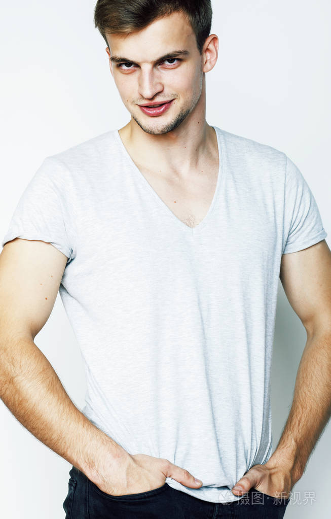 年轻帅气的十几岁的时髦男人摆出动情的姿势,开心的微笑在白色背景下