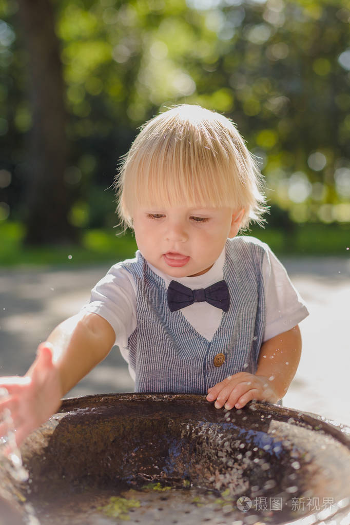 漂亮的小男孩在公园里玩水