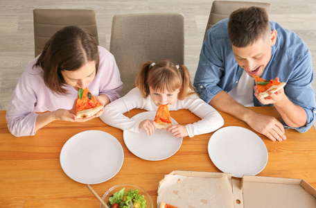 快乐的一家人在家吃披萨图片