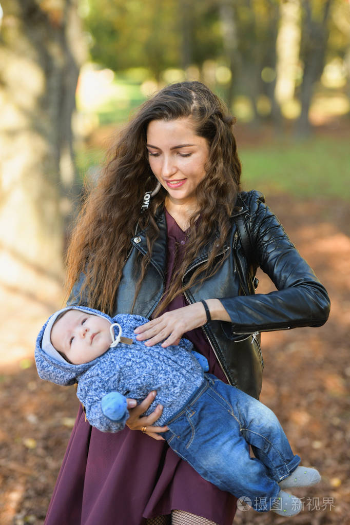 一个快乐的母亲和婴儿笑的肖像.抱着孩子的年轻母亲