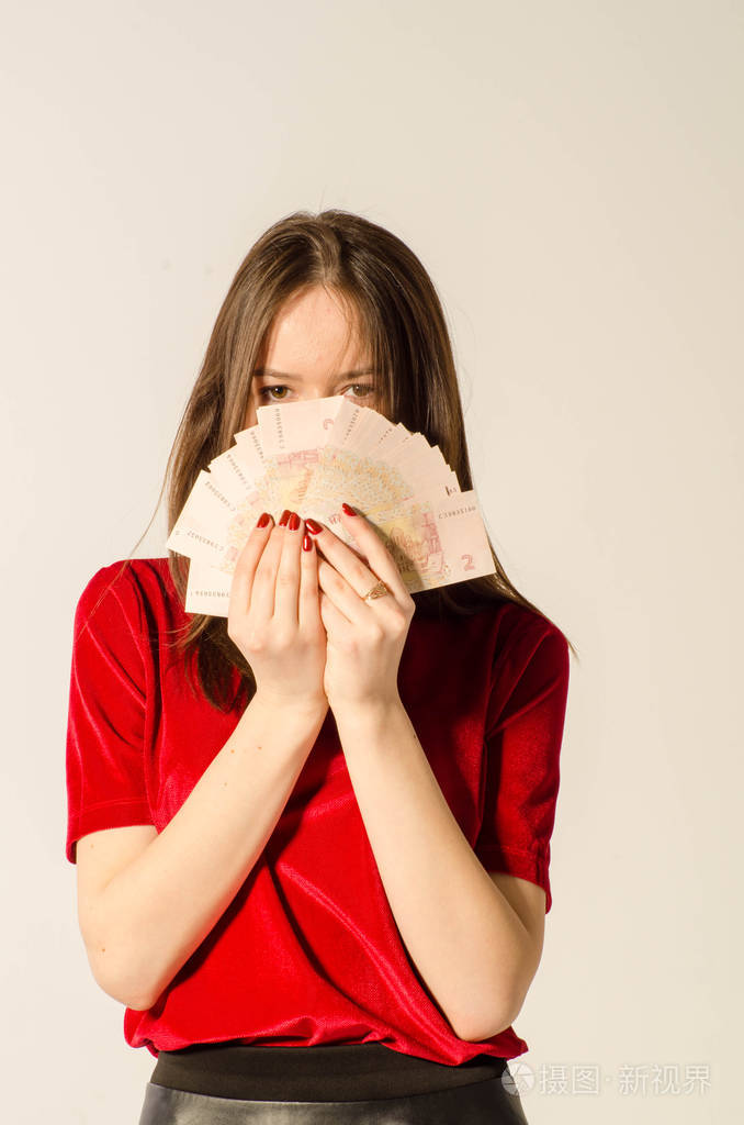 一个性感的黑发女人穿着浅底色的短裙数钱