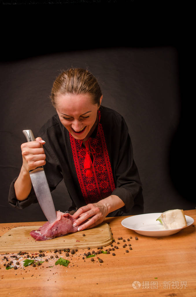 女性手拿刀在桌子上切新鲜的肉
