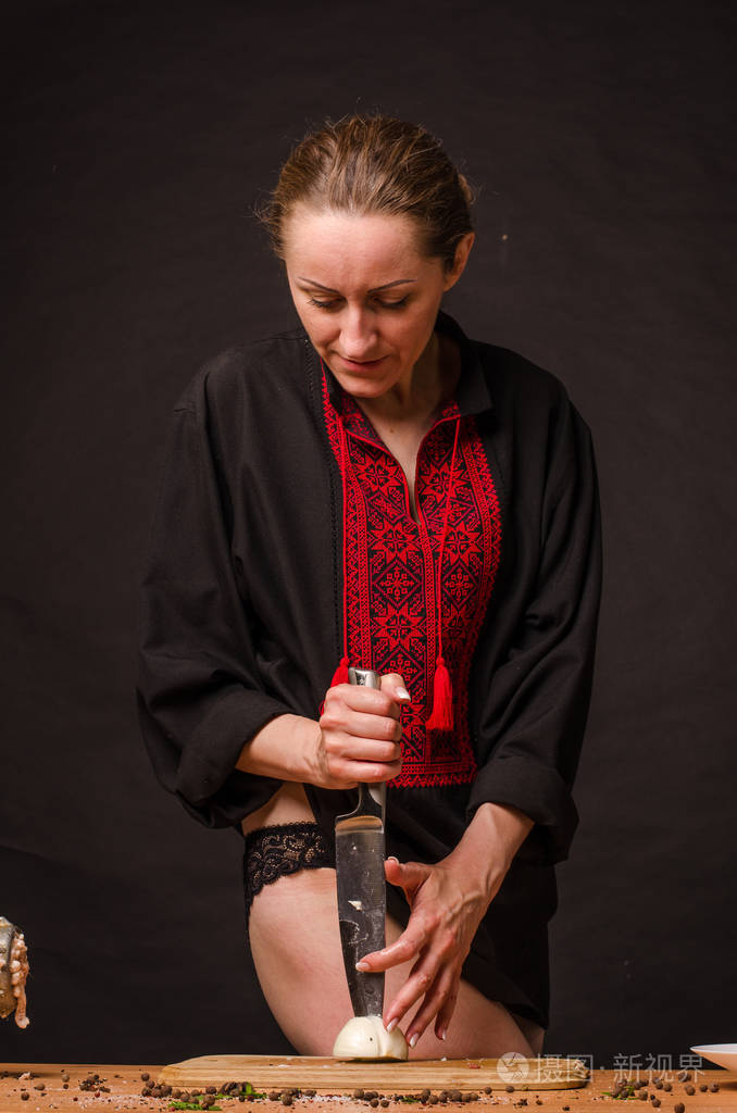 女孩的手拿着刀在木板上切洋葱