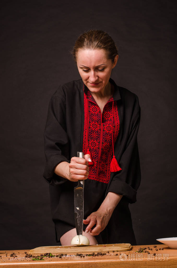 女孩的手拿着刀在木板上切洋葱照片-正版商用图片2os96f-摄图新视界