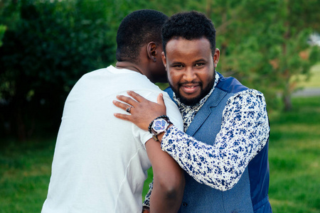 非洲裔美国人朋友拉美裔商人拥抱拥抱问候在户外团队合作照片