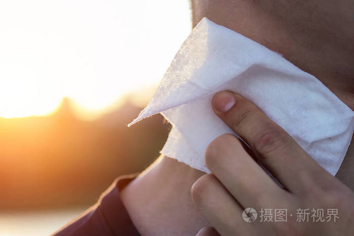 人的手用湿纸巾擦拭身体部位