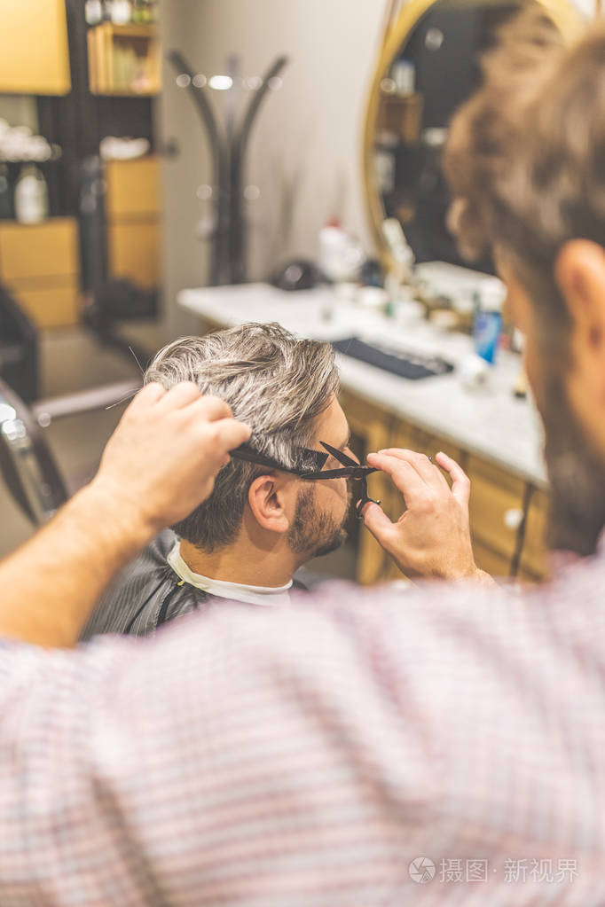 理发师用剪刀和梳子剪头发