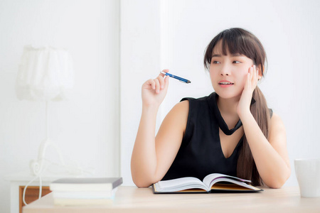 美丽的亚洲女作家微笑的思维理念与写作照片
