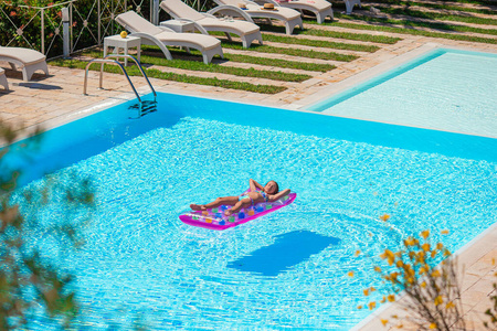 可爱的小朋友在室外游泳池玩耍照片