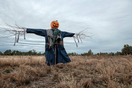 在多云的天气里一个带着万圣节南瓜头的吓人的稻草人万圣节背景复制