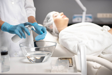 美容师戴着消毒手套在清洁海绵上喷洒插画