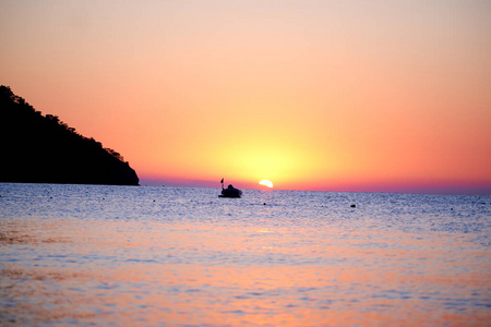 橘黄色的夕阳在海面上与船惊人的金色反射太阳平静的波浪照片