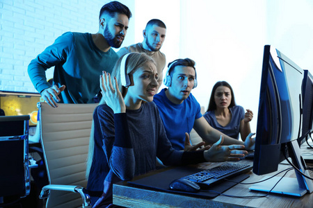 电脑竞技年轻人在室内玩电脑游戏.电子竞技锦标赛照片