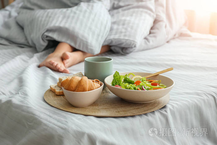 躺在床上吃着美味早餐的女人
