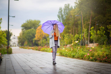 在秋城公园散步在草地上打开紫色的雨伞雨伞野营雨安全天气的商业标志