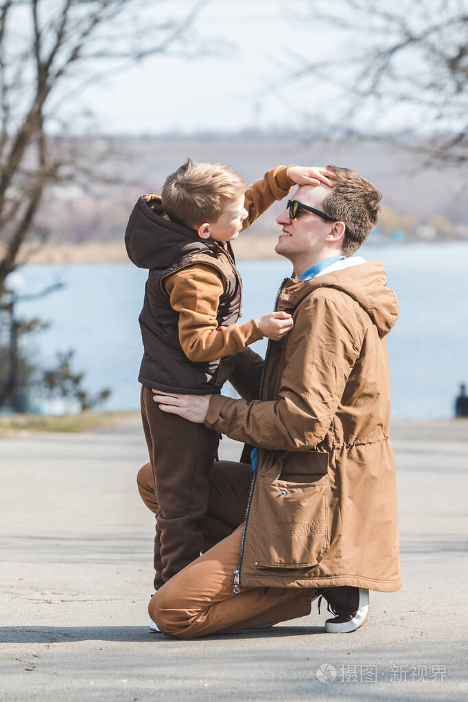 父亲在户外拥抱小儿子