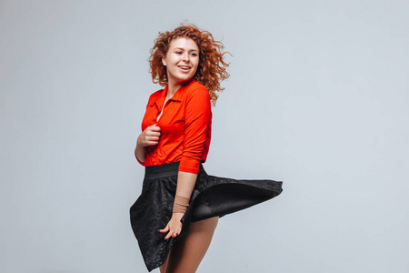 风吹开裙子裙子在风中飘动着,红发女孩骑着浅灰色的短裙照片