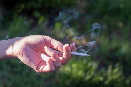 一只手拿着阴燃的香烟图片