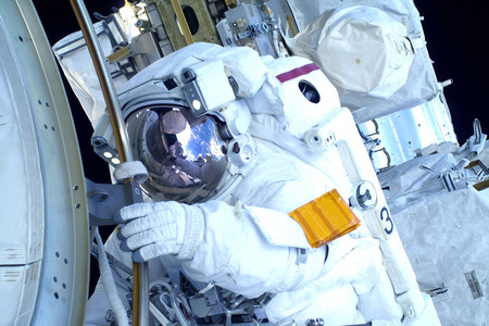 美国旗帜元素穿着太空服的宇航员.在空间站.从事维修工作.