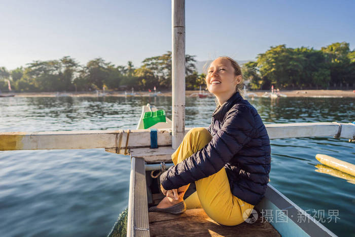年轻的女旅行者在海上乘船迎接黎明