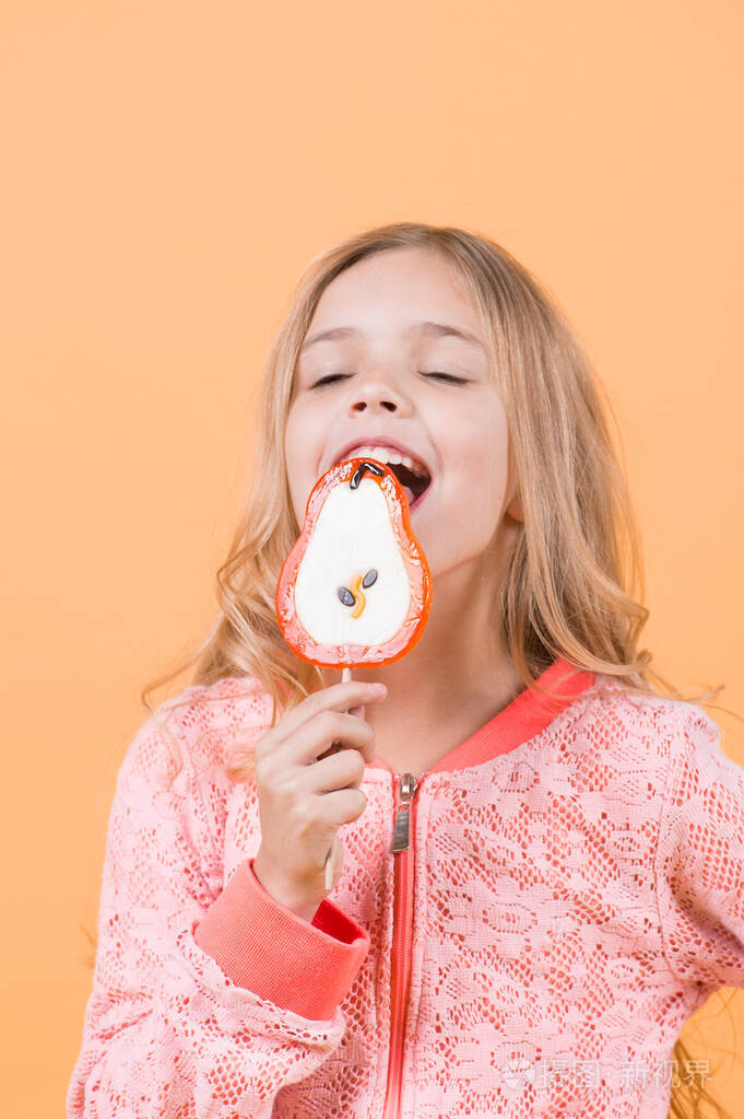 小女孩舔着棒子上的糖果