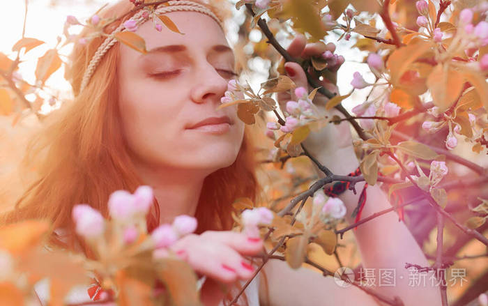 A girl on a walk in a park. Young redhaired girl in the spring 