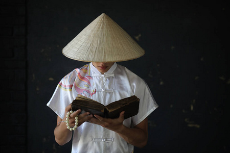 黑墙上戴帽子的亚洲小和尚照片