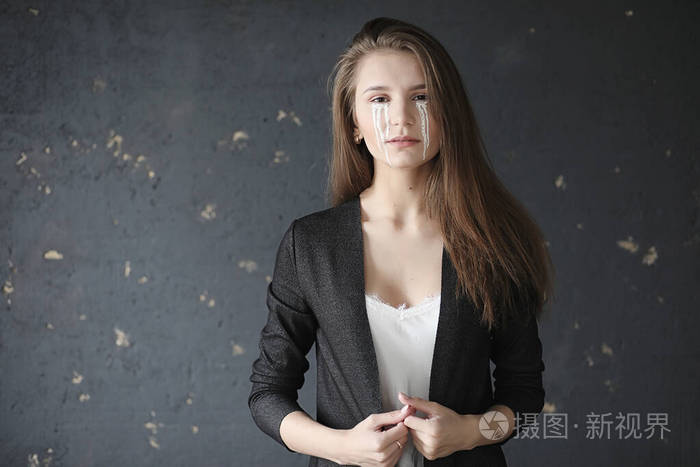 眼含泪水的美丽女孩画着t字的小女孩