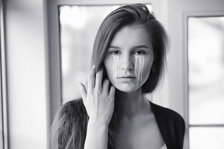 眼含泪水的美丽女孩.画着t字的小女孩照片