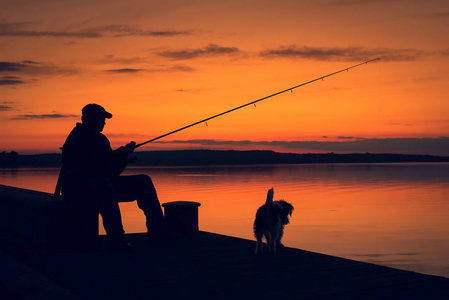 夕阳渔夫渔夫在夕阳下钓鱼.照片
