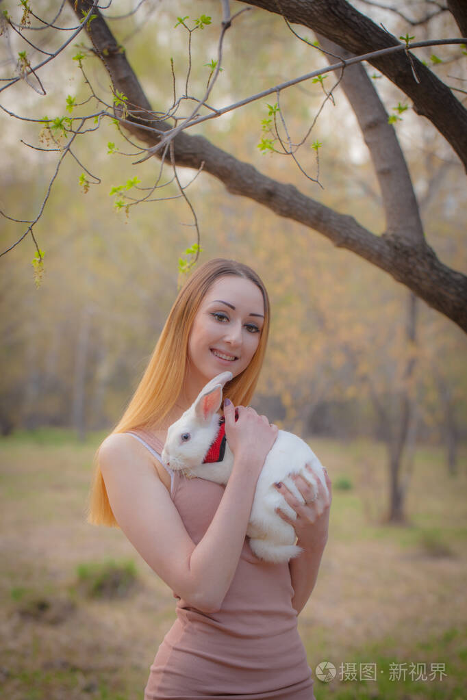 宠物的概念美丽的女孩抱着一只兔子