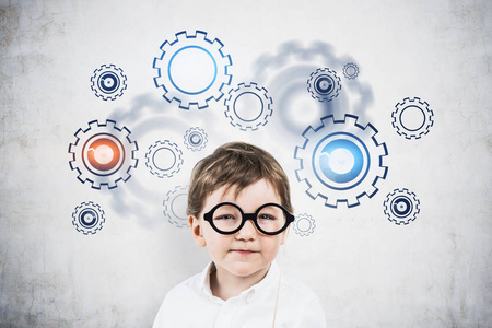 可爱的小男孩脑力激荡,齿轮草图照片