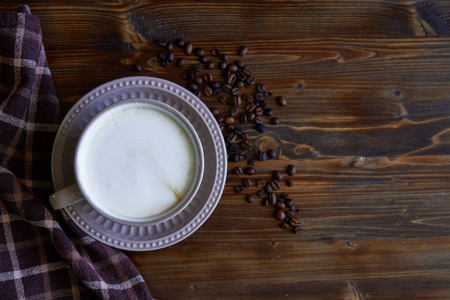 木制背景的卡布奇诺咖啡豆杯照片