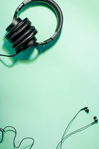 薄荷娱乐不同类型的耳机平放在薄荷色背景上,复制空间.
