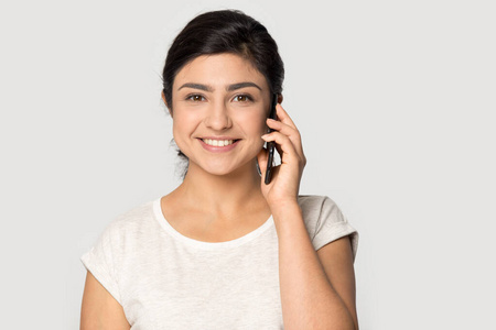 使用手机头像笑眯眯的印度女孩看着摄像机对着手机说话照片