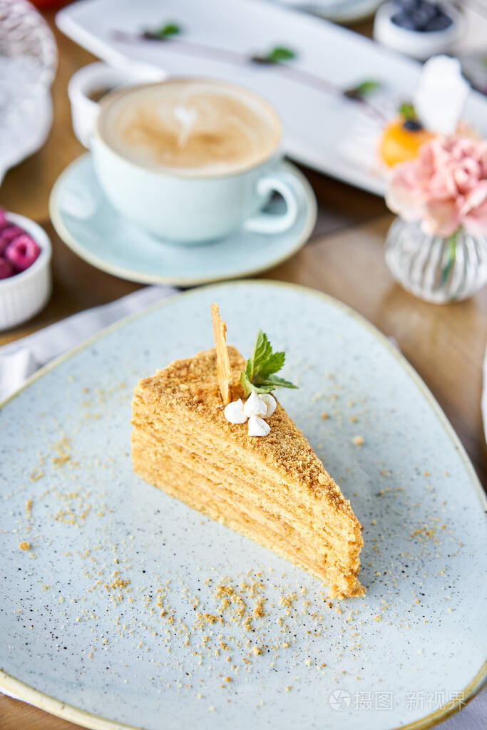 在咖啡厅吃早餐,早上喝咖啡.卡布奇诺和很多甜点在桌上.