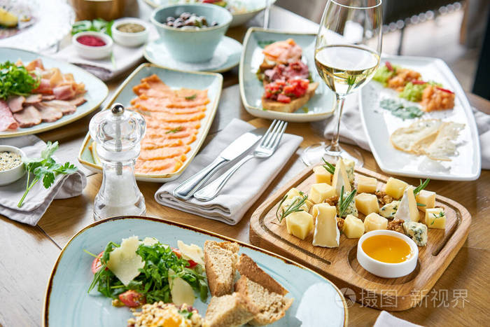 桌上摆着各种小吃和消炎药餐厅菜单奶酪盘子把美味的奶酪和核桃蜂蜜