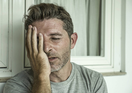 中年悲伤抑郁的男人在痛苦中感受压力和挫败的戏剧性肖像,遭受抑郁