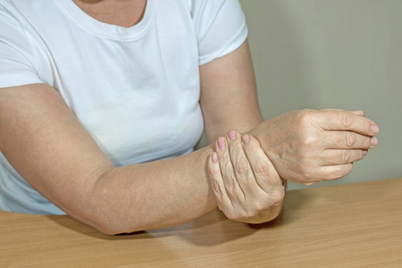 一位老妇人抓住左手酸痛的手腕插画